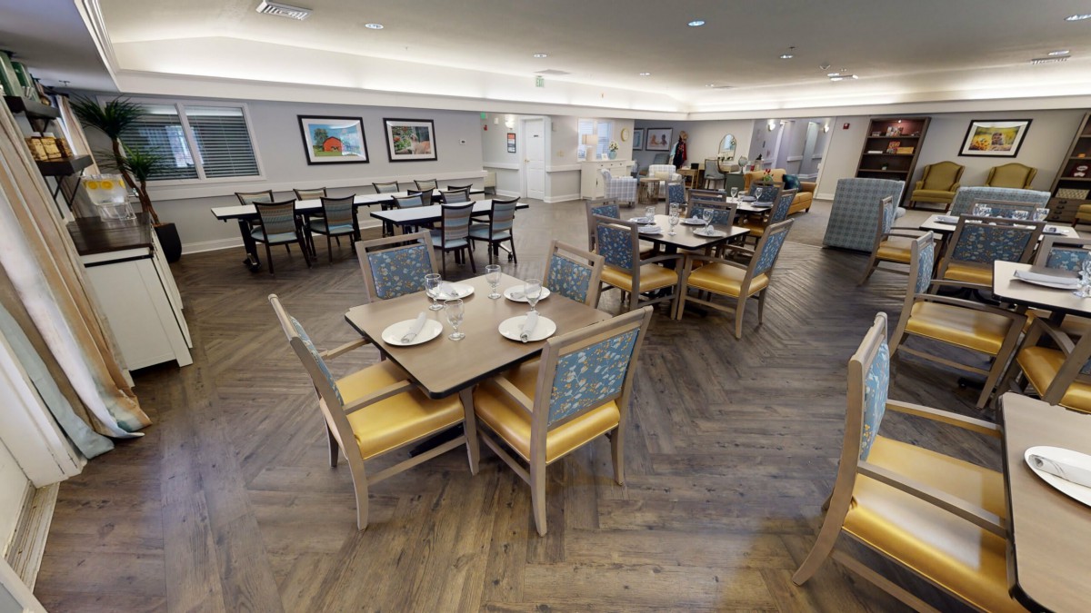 A modern restaurant dining area with neatly arranged tables and chairs, featuring elegant interior design.