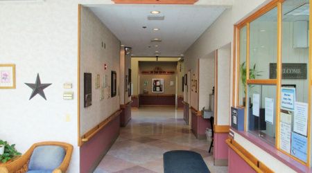 A well-lit hallway with artwork and doors leading to various rooms.