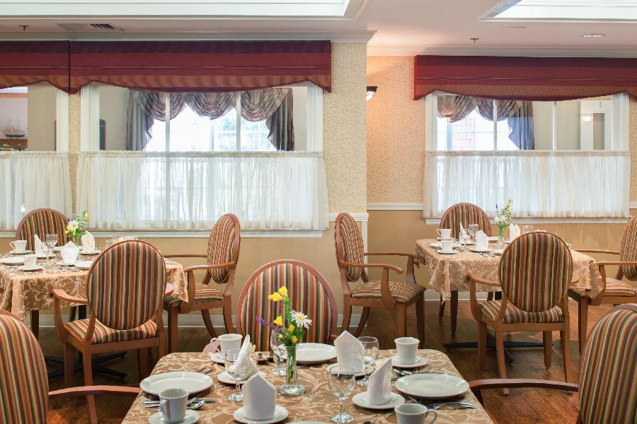 A well-arranged dining room with elegantly set tables and comfortable chairs.
