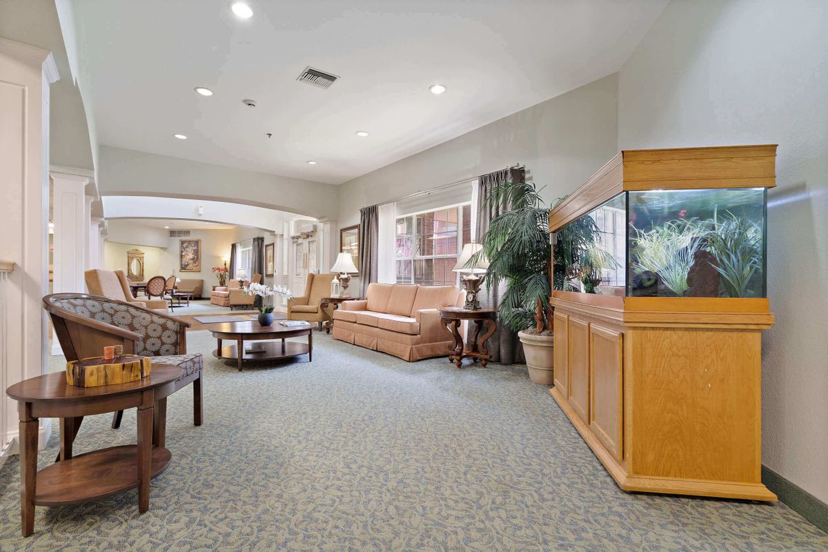 A spacious lobby with comfortable seating, a large fish tank, and abundant natural light.