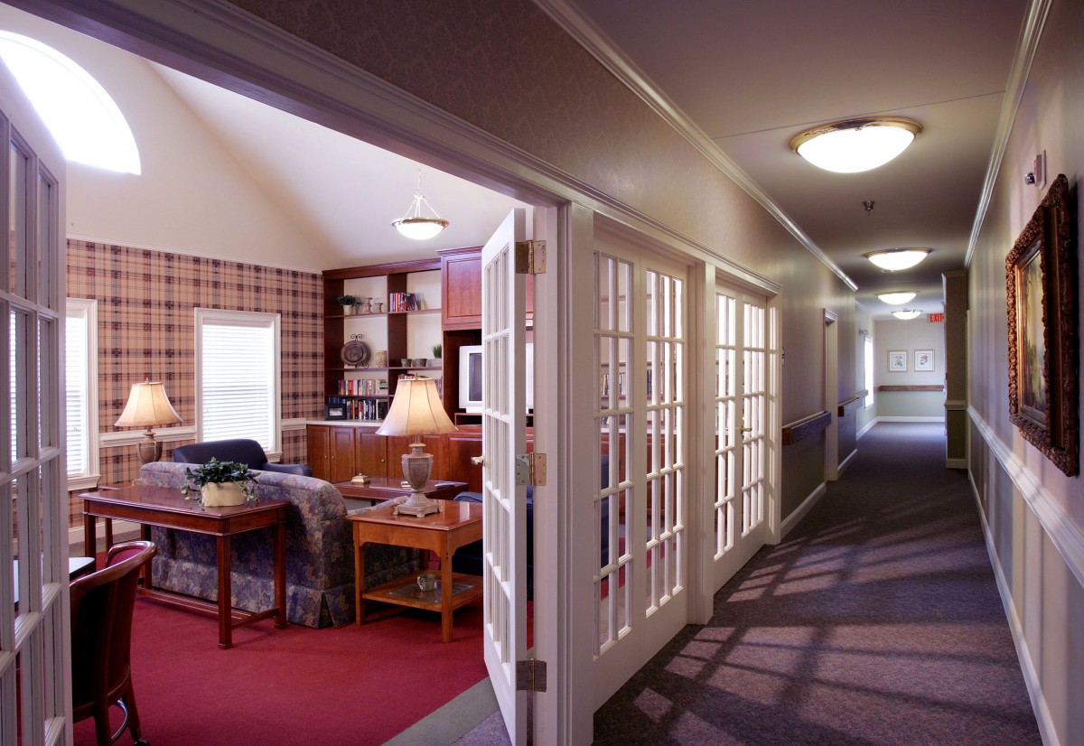 A well-lit hallway with French doors leading to a cozy living room.