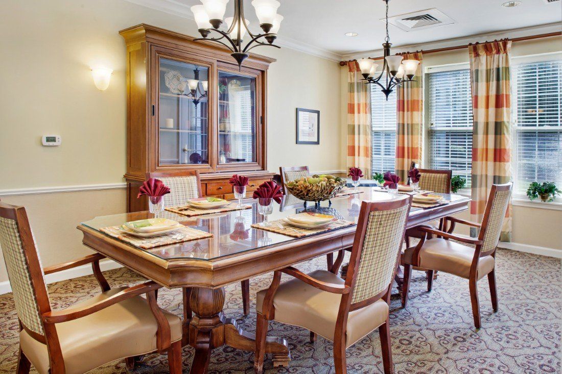 A well-appointed dining room with a large table set for a meal, complemented by elegant chairs and lighting.