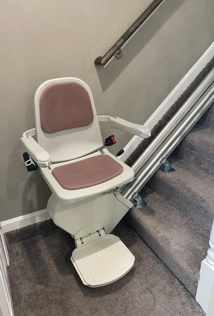 A stairlift installed on a residential staircase, designed to assist with mobility and accessibility.