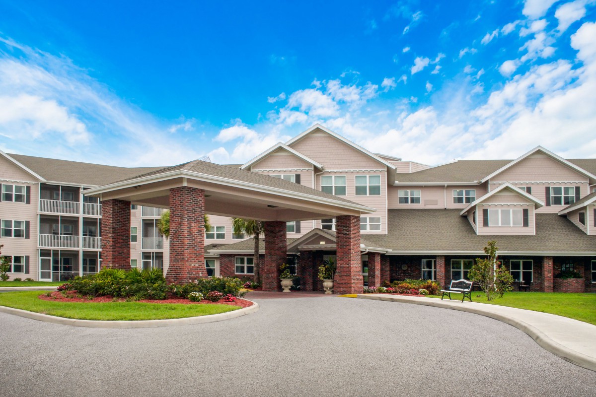 A large residential building with an inviting entrance under a clear blue sky.