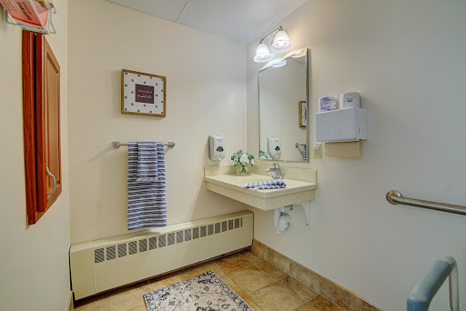 A well-lit bathroom featuring a sink, mirror, and decorative elements.