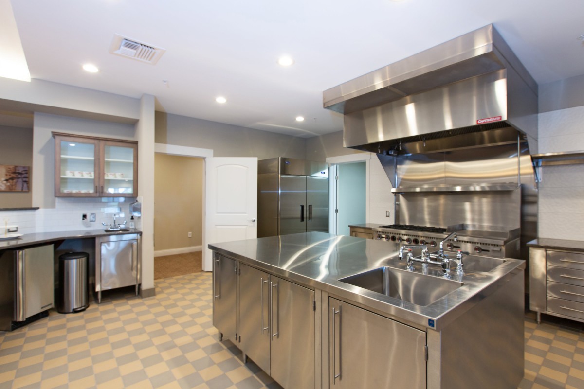 A spacious commercial kitchen featuring stainless steel appliances and surfaces.