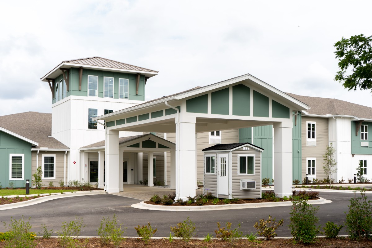 A modern residential building with a welcoming entrance and landscaped surroundings.
