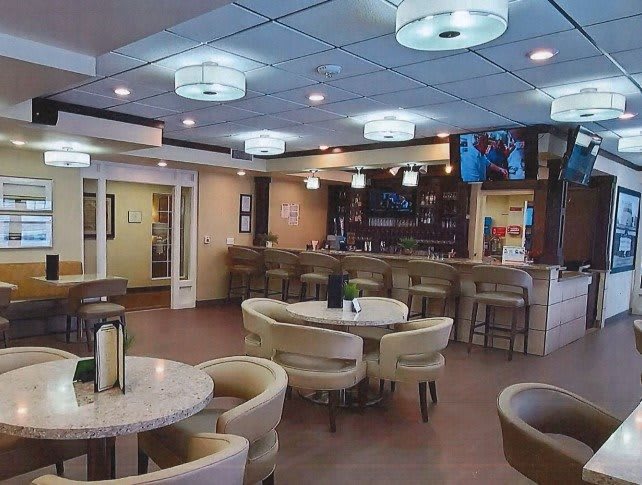 A modern restaurant interior featuring a bar counter and comfortable seating.