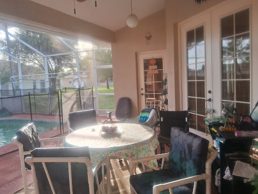 A cozy patio area illuminated by warm sunlight, featuring a round table and comfortable chairs.