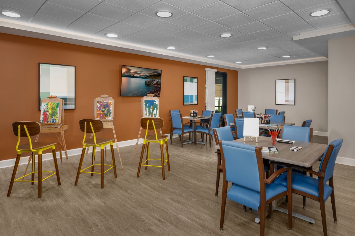 A modern dining area with blue chairs and wooden tables, featuring a casual and inviting atmosphere.