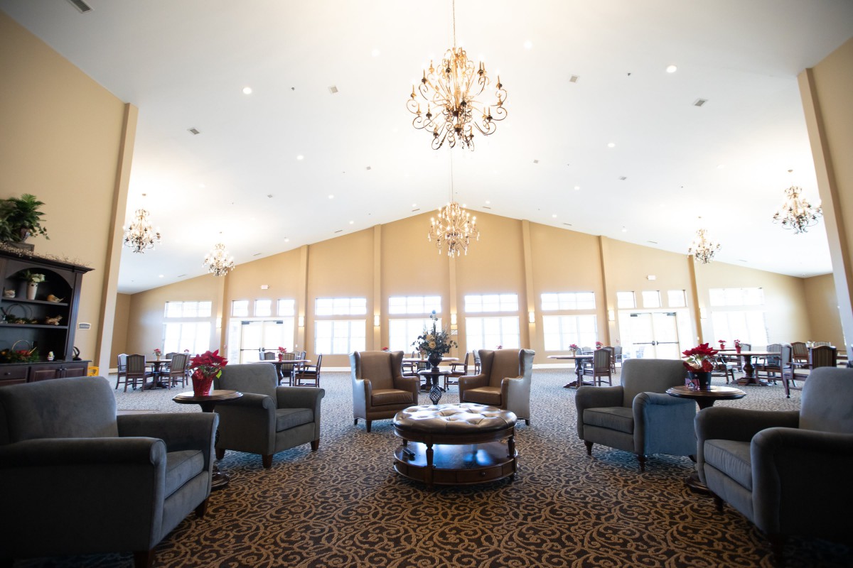 A spacious lounge with elegant chandeliers, comfortable seating, and large windows.