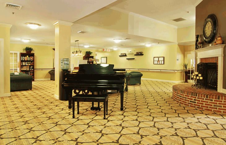 A spacious hotel lobby featuring a grand piano and stylish furnishings.
