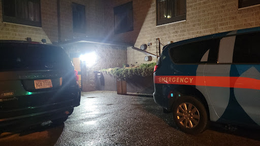 Emergency response vehicles parked outside a building at night.