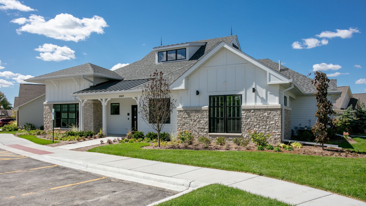 A modern suburban house with a stone facade and well-maintained landscaping.