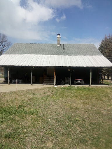 A rural house with a metal roof and covered porch.