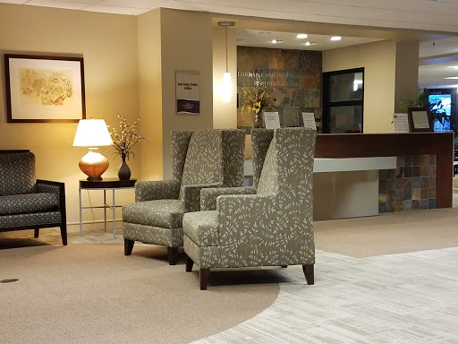 A cozy seating area featuring patterned armchairs, a side table, and a warm lamp.