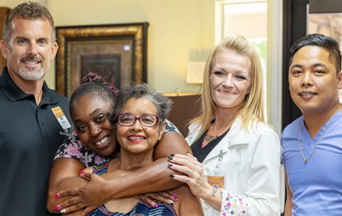 A group of smiling friends posing together indoors.