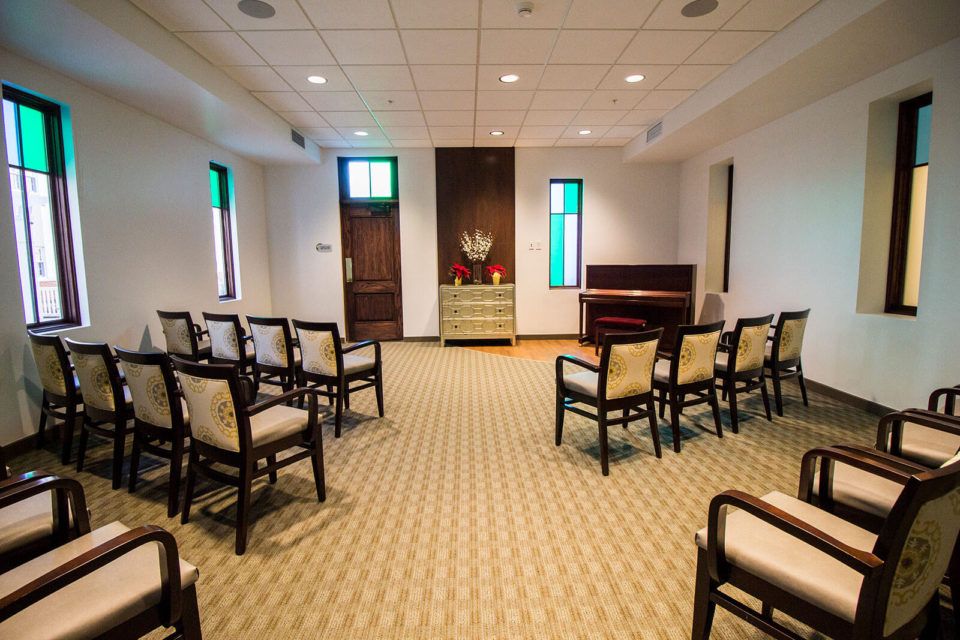 A neatly arranged meeting room with chairs facing a small altar or podium.
