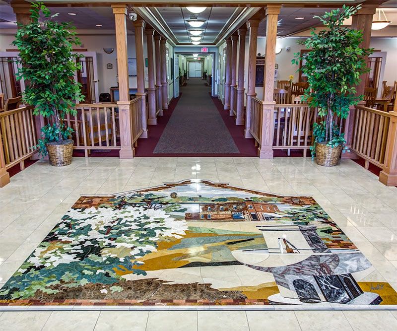 A beautifully decorated hallway featuring a large, colorful rug and potted plants.