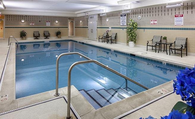 An indoor swimming pool with seating and decor, offering a space for relaxation and leisure.