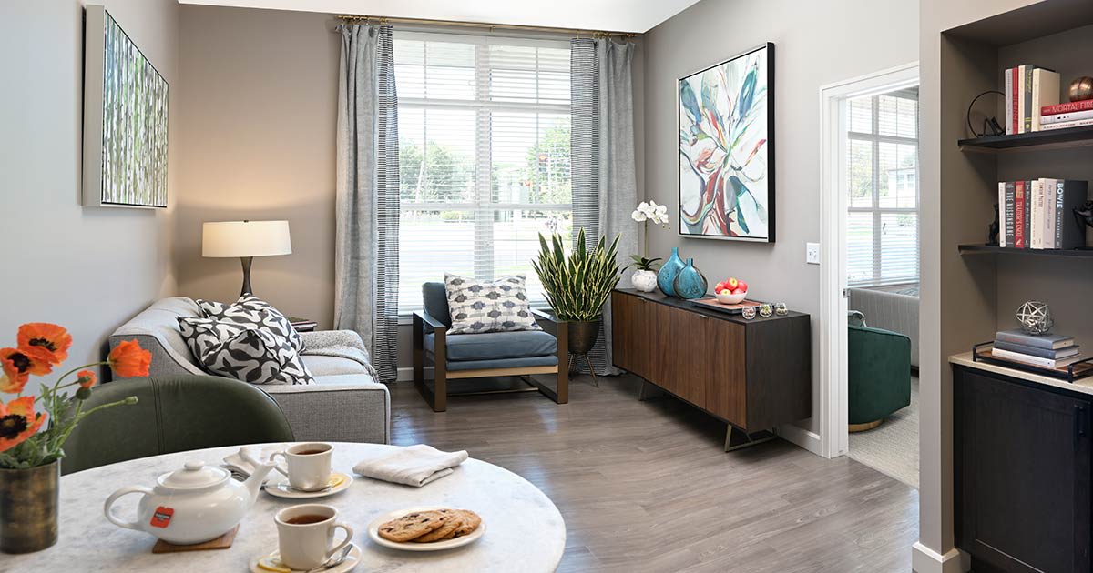 A modern living room with stylish furniture and a large window letting in natural light.