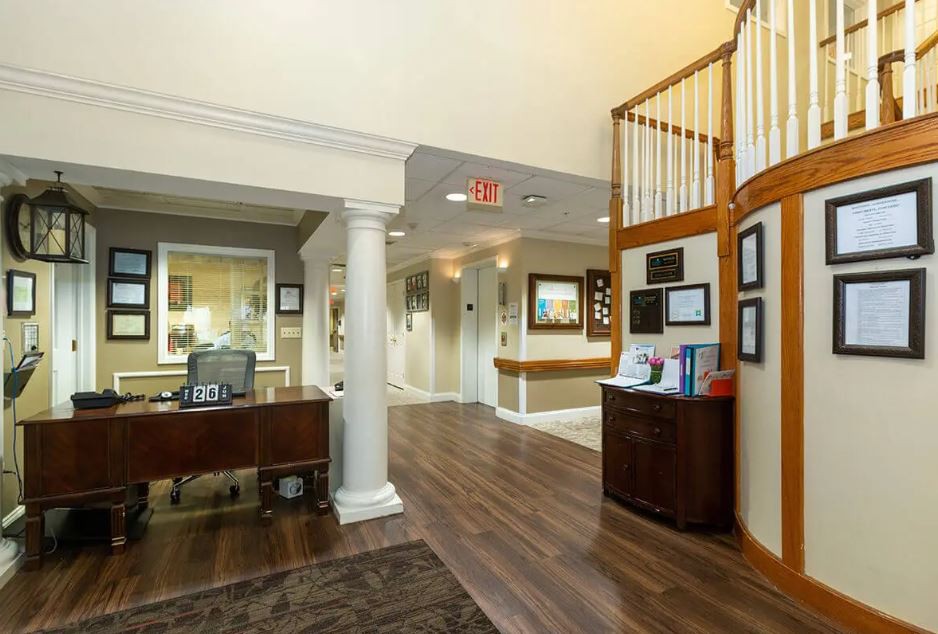 A reception area with a desk, artwork on the walls, and a hallway leading further inside.