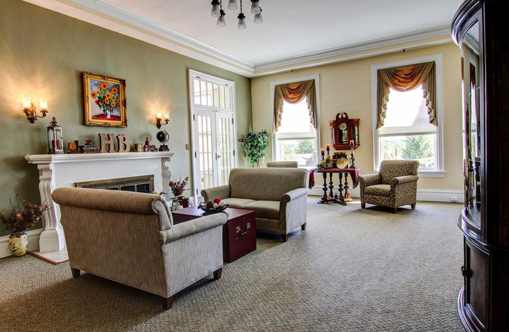 A spacious and elegantly decorated living room with comfortable sofas, a fireplace, and large windows letting in natural light.