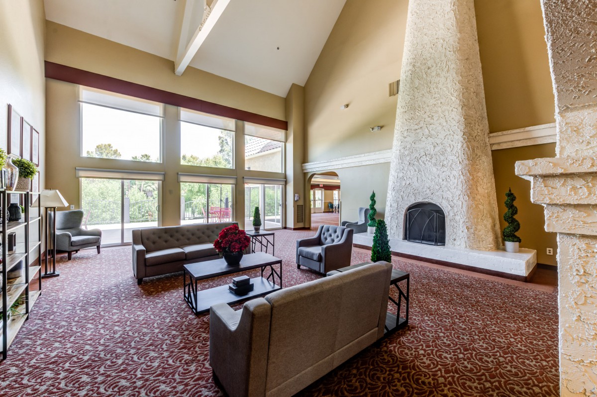 A spacious and modern lobby area with large windows and a prominent fireplace.