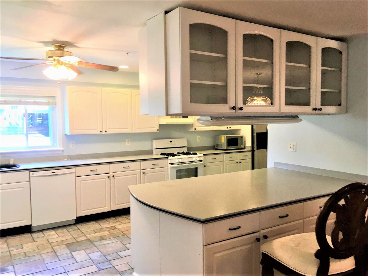 A modern kitchen interior with white cabinets and a spacious countertop.