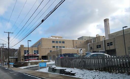 A view of a hospital building alongside a snowy road.