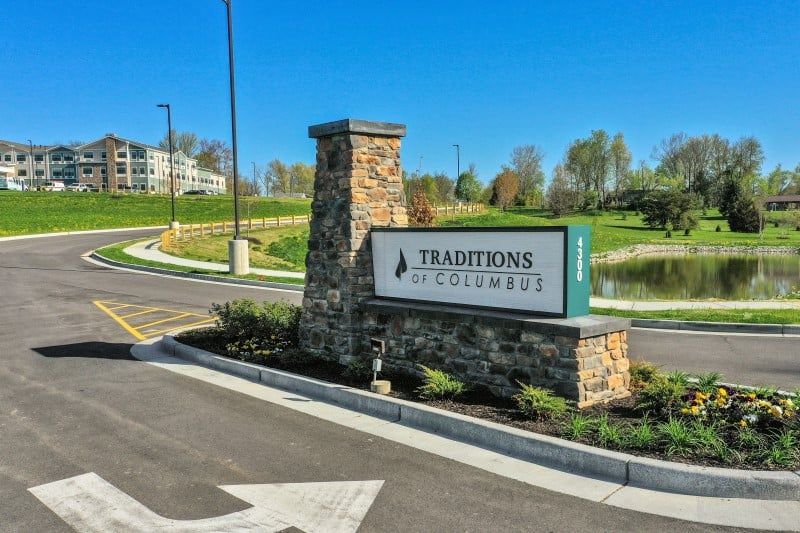Entrance sign for Traditions of America at Cranberry with landscaped surroundings.