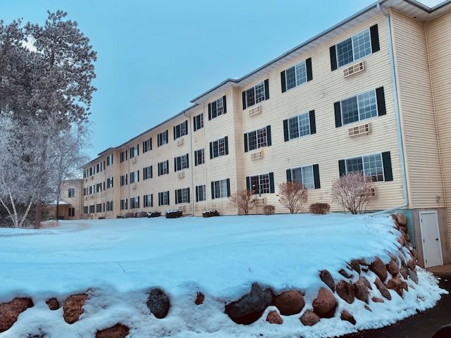A residential apartment building surrounded by snow on a winter day.