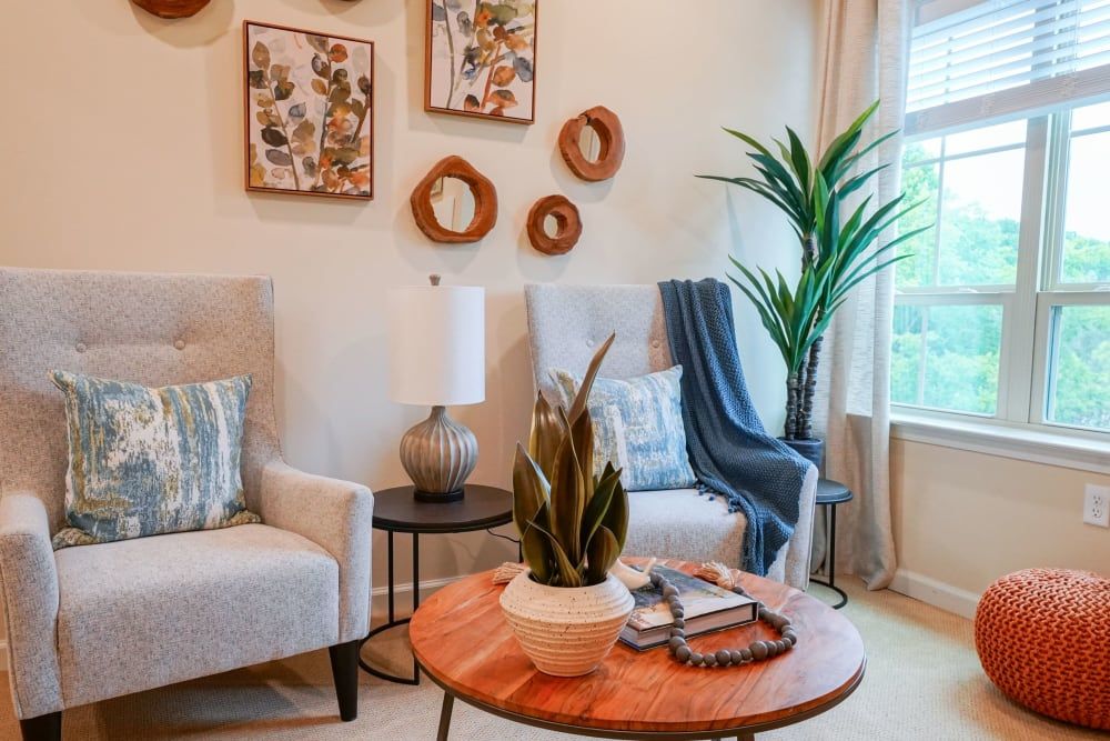 A cozy living room with comfortable armchairs, a wooden coffee table, and stylish wall art.