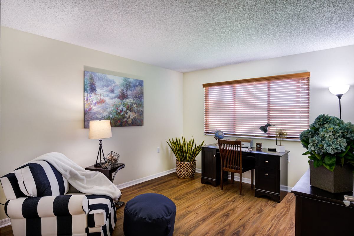 A cozy home office with a desk, chair, and decorative elements.