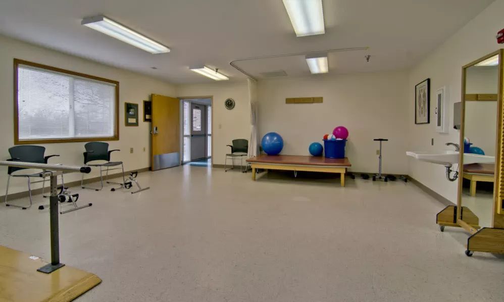 An empty exercise room with yoga balls and gym equipment.