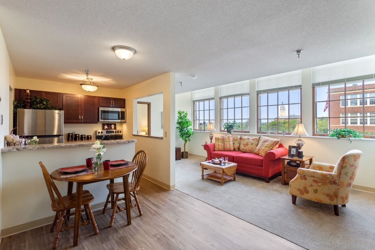 A cozy apartment with an open living room, dining area, and kitchen.