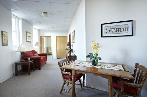A cozy living and dining space featuring a wooden table, chairs, and decorative elements.