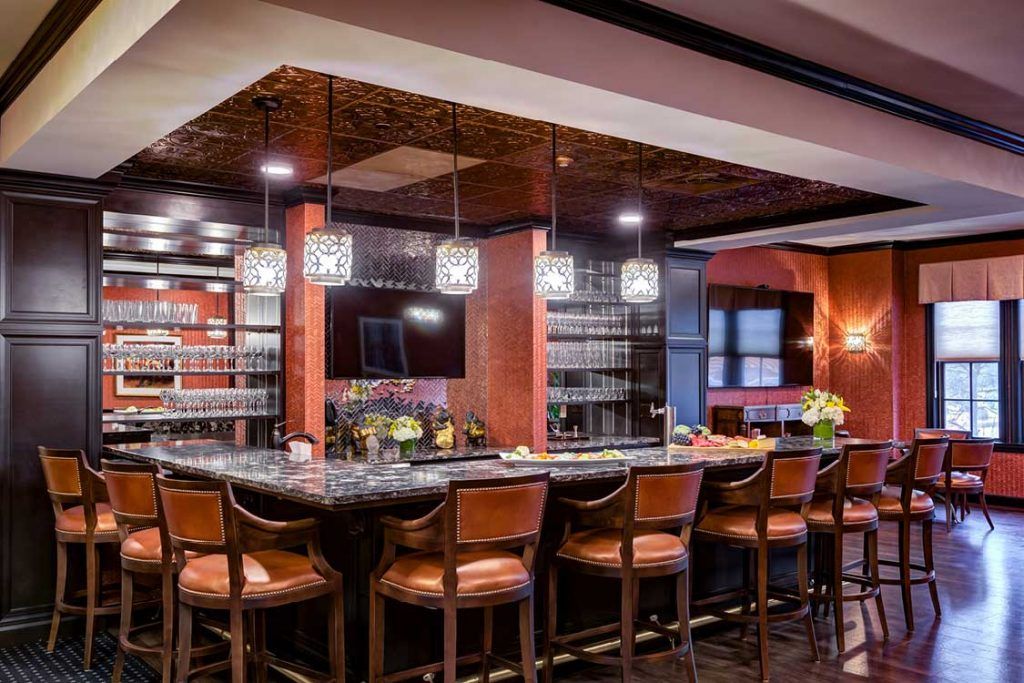 A luxurious bar interior with elegant seating and modern lighting.