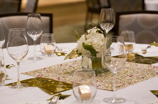 An elegantly set dining table adorned with fresh flowers and an intricate table runner.
