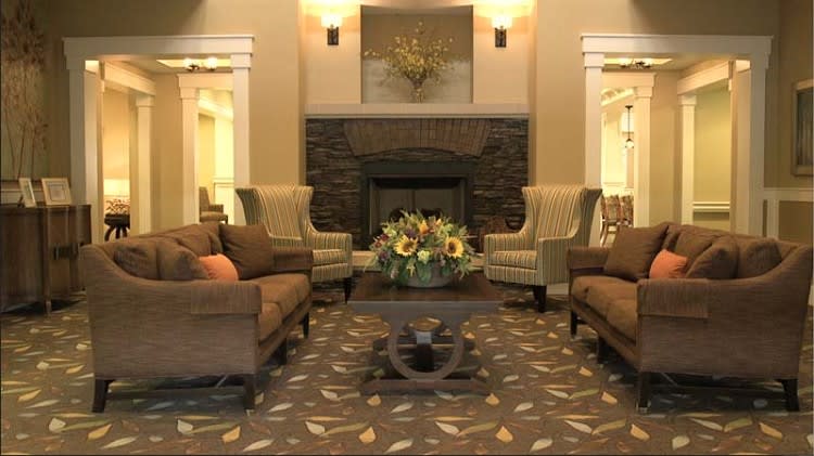 A cozy living room with sofas, armchairs, and a fireplace.