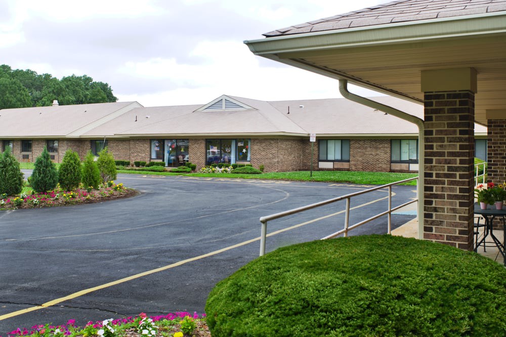A single-story brick building with a neatly landscaped driveway.