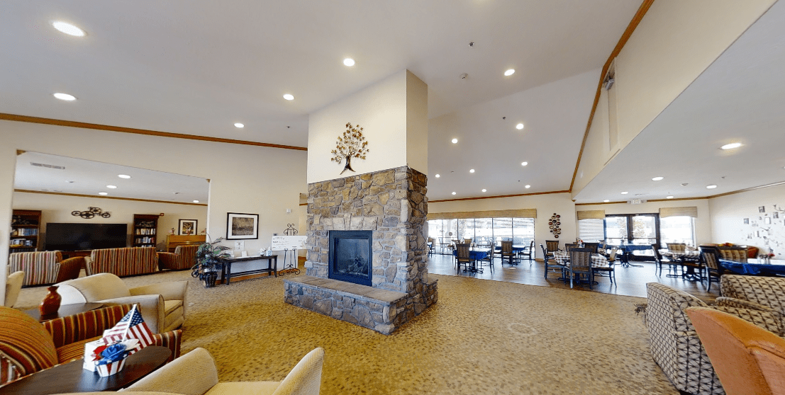 A spacious and modern lobby featuring a central stone fireplace with surrounding seating.