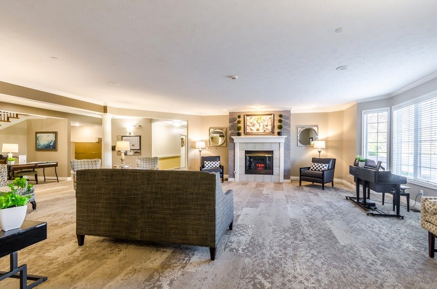 A spacious living room featuring modern decor with a central fireplace and cozy seating area.