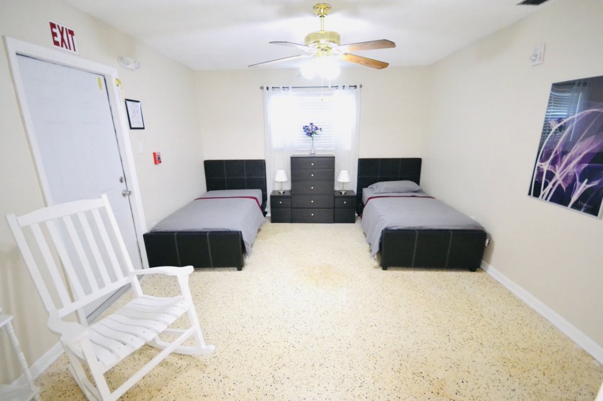 A bedroom with twin beds, a dresser between them, and a rocking chair in the corner.