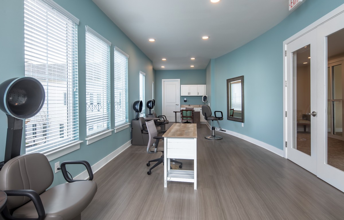 A modern office space with blue walls, featuring a desk and several chairs, all arranged in a minimalist style.