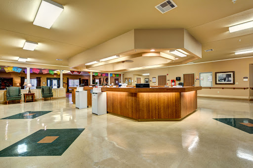 A spacious and modern reception area with a wooden counter and comfortable waiting space.