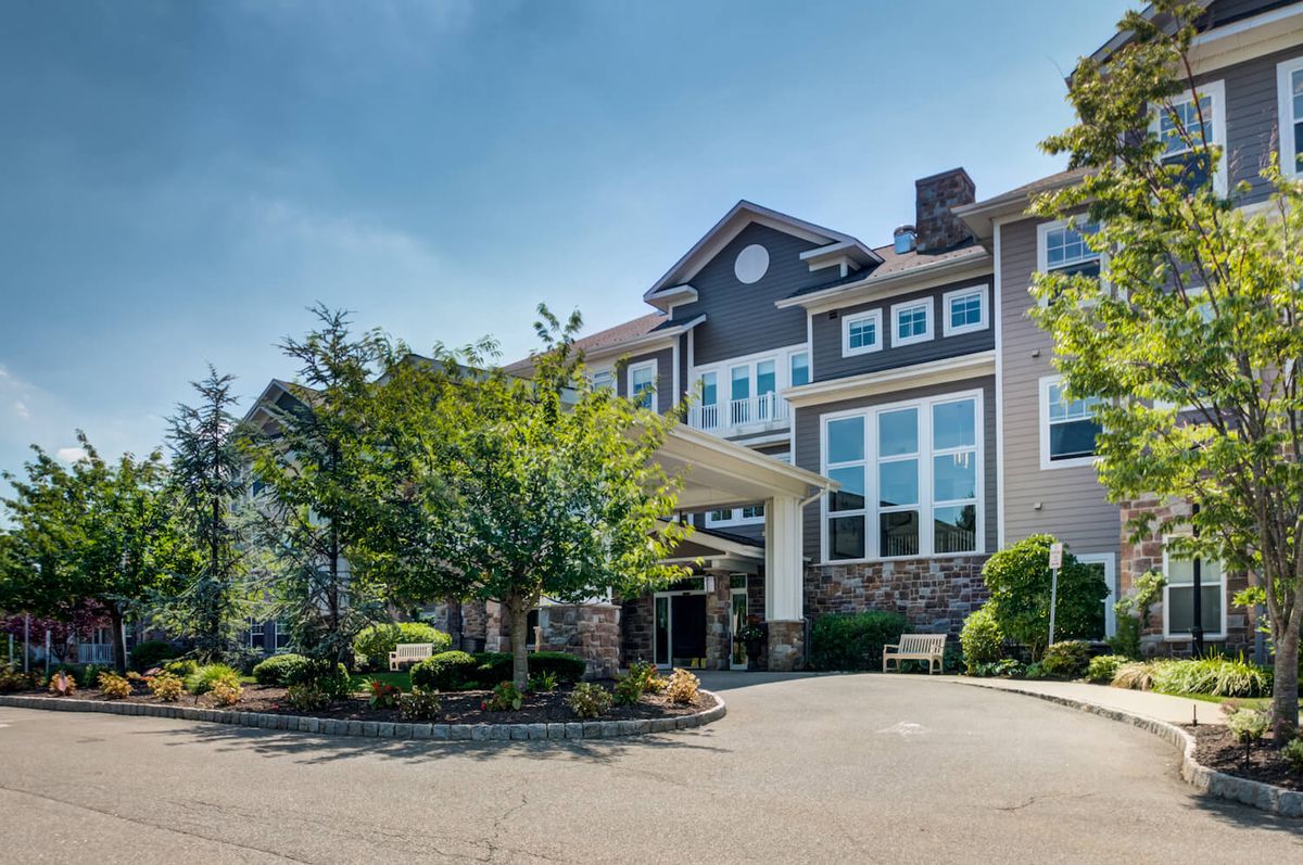 A large residential building surrounded by trees and landscaping.
