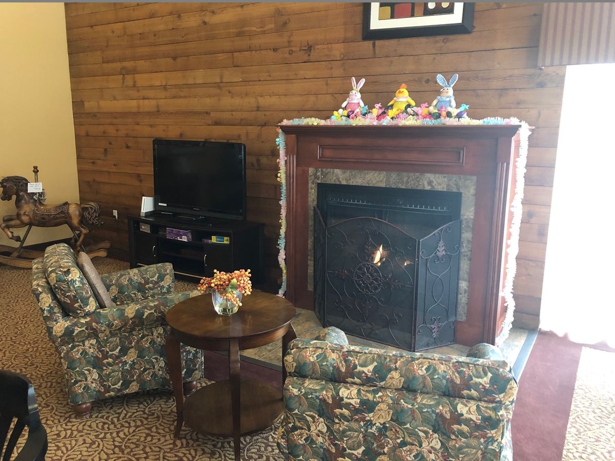 Cozy living room with a fireplace and floral furniture.