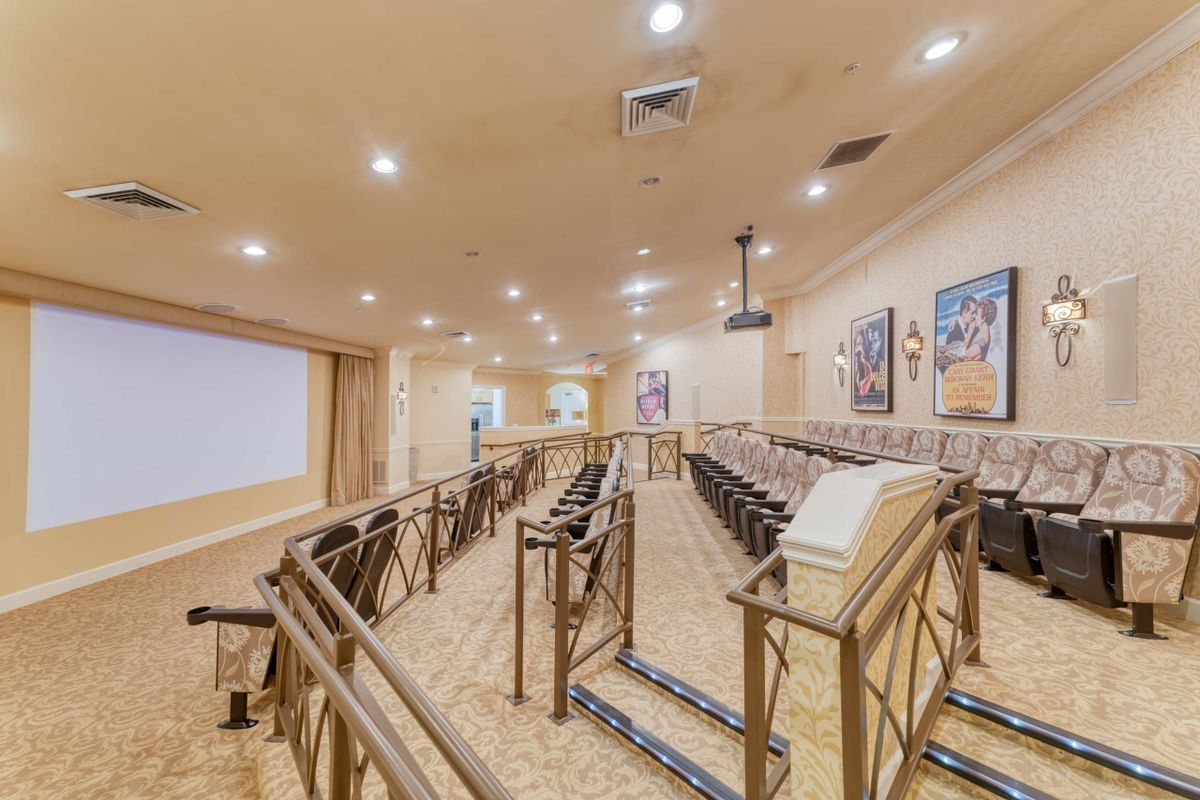 A small auditorium with tiered seating and a projector screen for presentations.