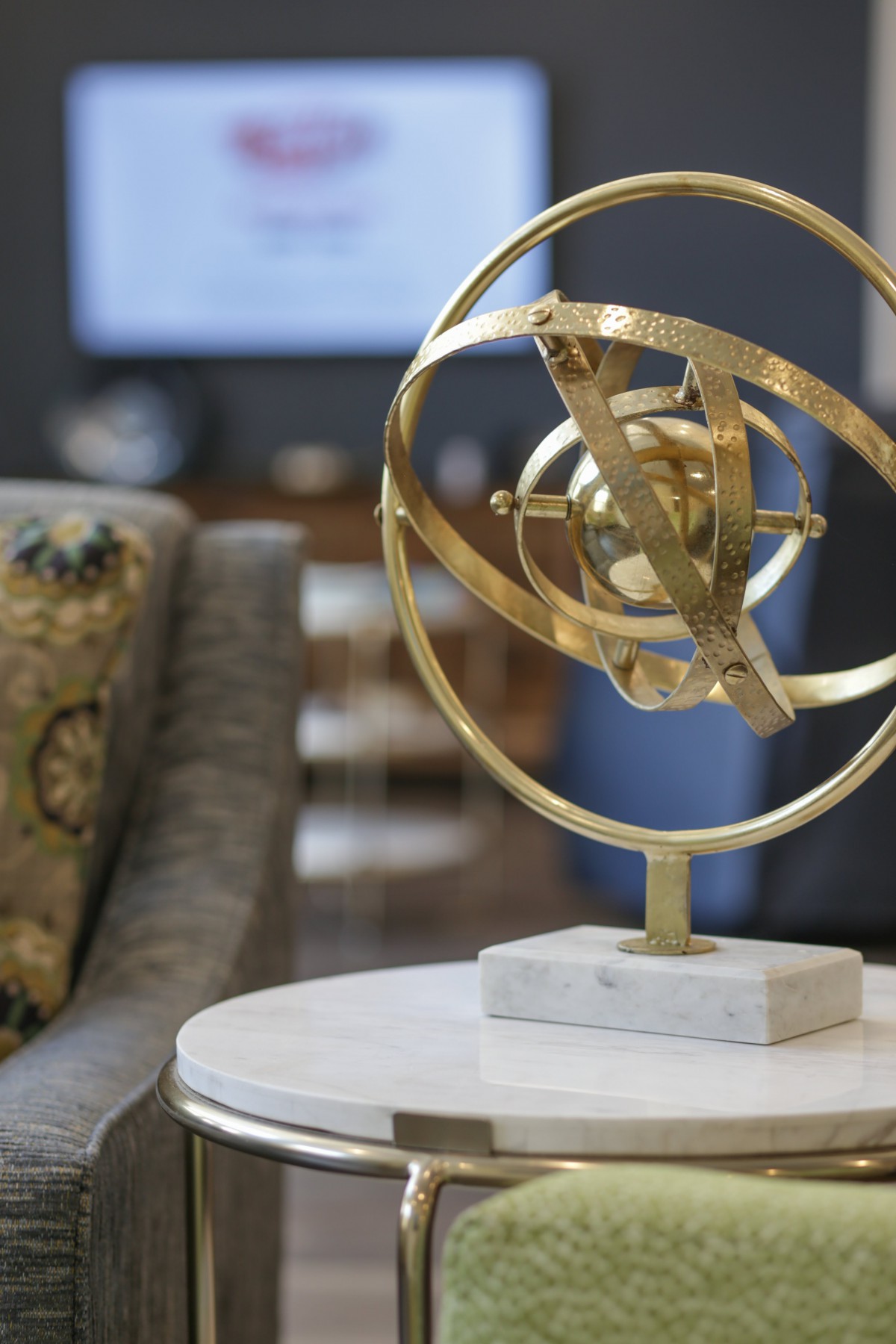 A modern decorative orb sculpture on a marble table adds elegance to the interior setting.